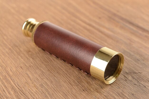 Modern spyglass on wooden background