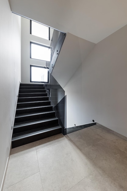 Modern stairs with glass handrails in the interior of a\
multistorey modern house