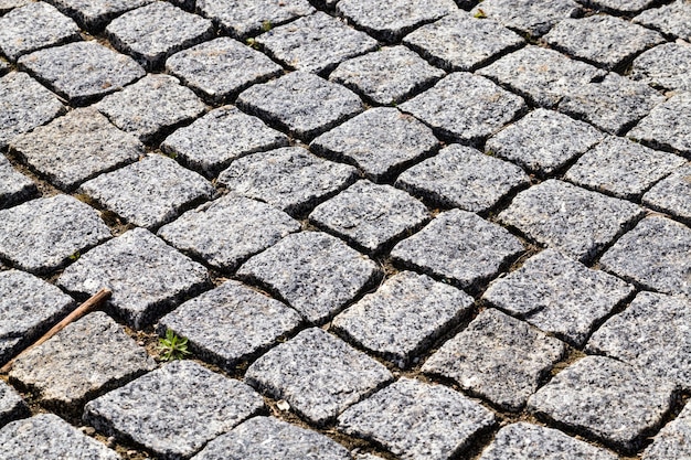 Modern stone and cobblestone road creating an imitation of an old, closeup