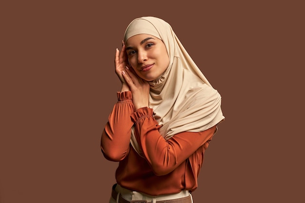 Moderna ed elegante bella donna musulmana vestita con pantaloni beige giacca arancione hijab beige