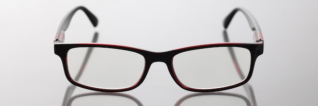 Modern stylish glasses with dark frames on table optics selection concept