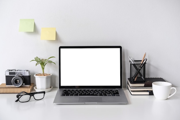 Photo modern and stylish workspace mock up with laptop and desk office supplies with white background and copy space