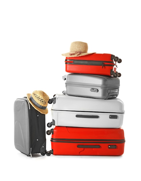 Modern suitcases and hats isolated on white