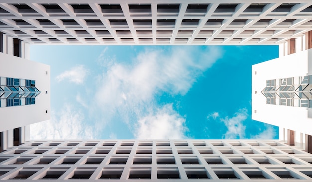 Foto costruzione moderna di architettura simmetrica con il cielo nuvoloso blu, fondo del grattacielo delle nuvole