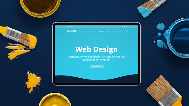 Modern tablet on a blue desk with creative flat design theme od web design studio Concept of creating modern web sites Color brushes and boxes beside