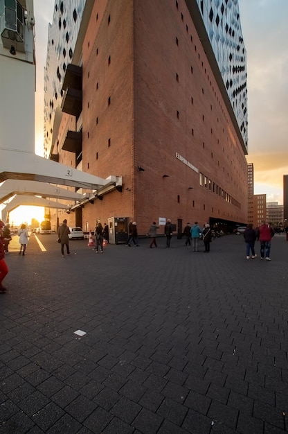 Modern tall glass building in the posh embassy tech village area workers carrying dustbin walking towards building