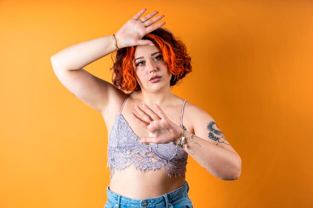 Modern tattooed nonbinary redhead girl with arms raised in defense