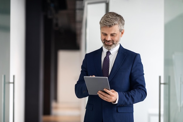 Modern Technologies Concept Smiling Mature Businessman Wearing Suit Using Digital Tablet Indoors