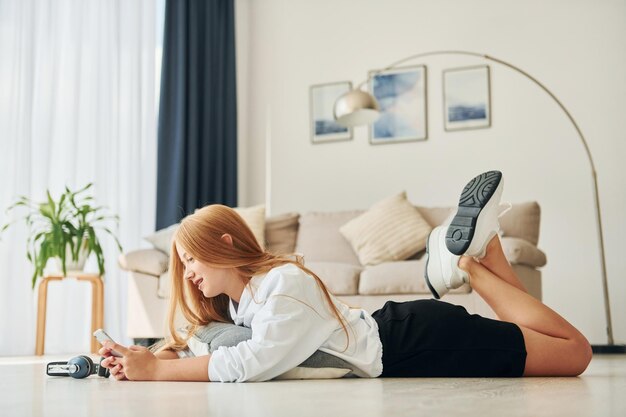 Modern technologies Female teenager with blonde hair is at home at daytime