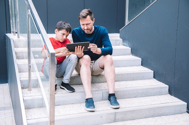 Tecnologie moderne nella vita della giovane famiglia. padre e figlio giocano su tablet. stile di vita.