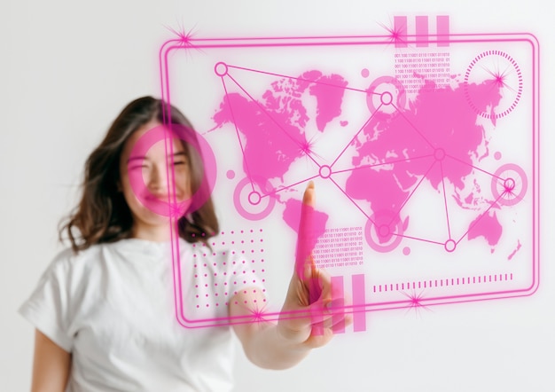 Modern technologies. Young asian woman's touching virtual reality in neon light on pink background. Concept of human emotions, facial expression, modern gadgets and technologies. Copyspace.