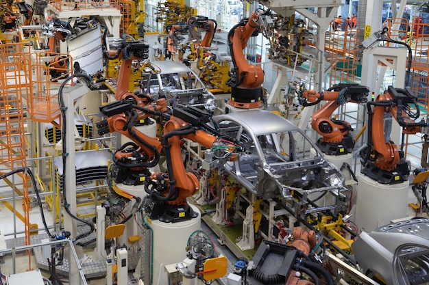 La moderna tecnologia di assemblaggio di automobili l'impianto dell'industria automobilistica negozio per la produzione e l'assemblaggio di macchine vista dall'alto il processo di saldatura di parti dell'auto