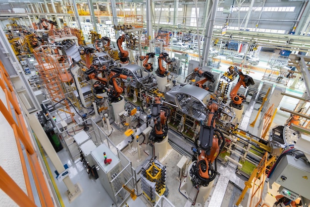 La moderna tecnologia di assemblaggio di automobili l'impianto dell'industria automobilistica negozio per la produzione e l'assemblaggio di macchine vista dall'alto il processo di saldatura di parti dell'auto