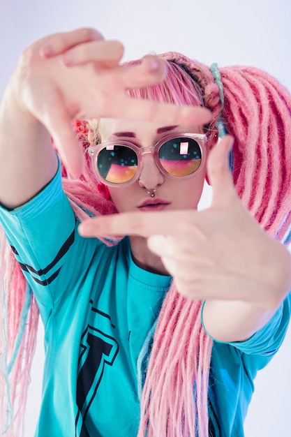 Modern teenage girl with pink dreadlocks on white background