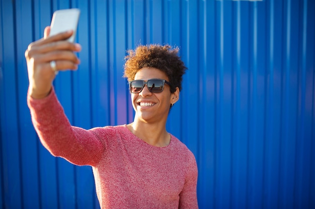 Modern teenage guy taking a self portrait over colorful background