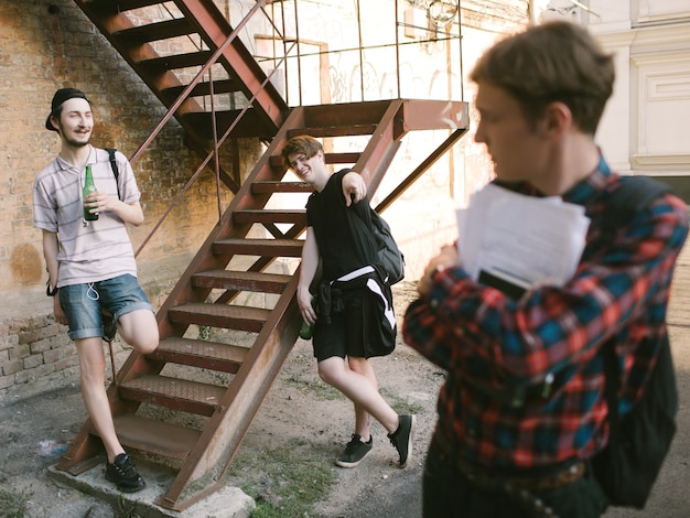 Foto stile di vita adolescenziale moderno. geek contro l'opposizione degli studenti di basso grado. bere alcol cattive abitudini. concetto di presa in giro