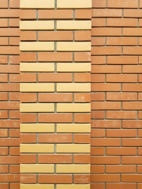 노란색 벽돌 장식이 있는 주황색 벽돌 벽의 현대적인 질감은 산업 건설의 배경 재료입니다
