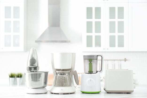 Modern toaster and other home appliances on white marble table in kitchen