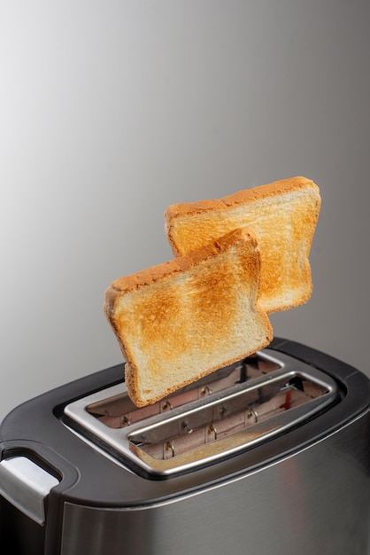 Foto il tostapane moderno con fette di pane croccanti in primo piano