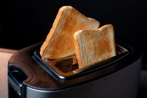 Modern toaster with crispy bread slices closeup