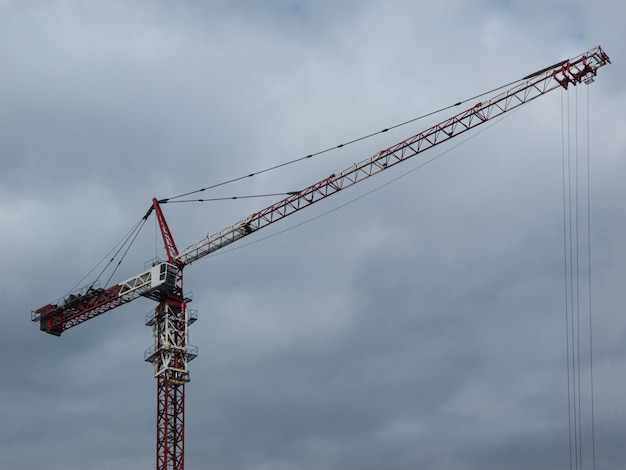 Modern tower crane on the background of the cloudy sky