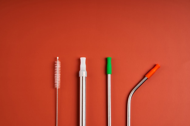 The modern trend caring for the environment. Self kit of reusable metal beverage straws of various diameters and shapes with cleaning tool and silicone caps.