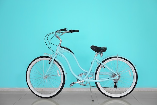 Bicicletta a due ruote moderna all'interno vicino alla parete di colore