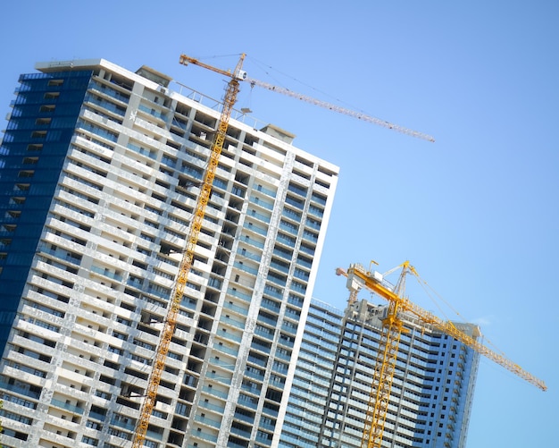 Modern unfinished buildings and lifting cranes