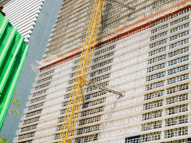 Modern unfinished skyscraper with a lifting crane