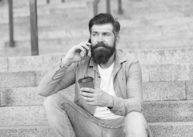 Modern urban life Bearded man phone conversation Mobile conversation Coffee break Personal communication Calling friend Pleasant conversation Real connect Drink coffee while talking