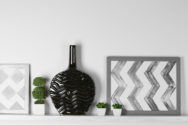 Modern vase with picture on shelf in room