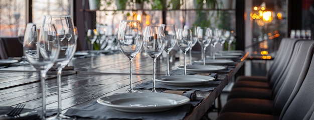 Modern veranda restaurant interior, banquet setting, glasses, plates