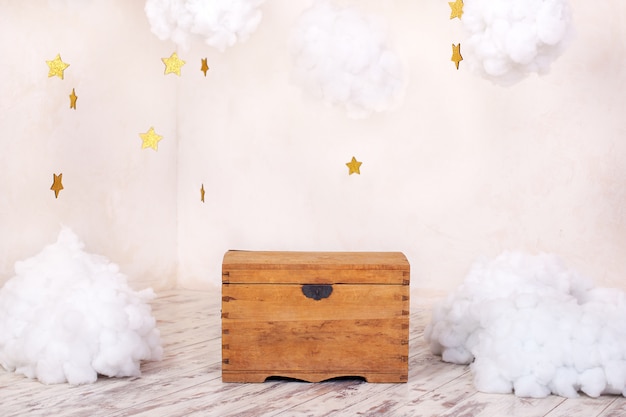 Modern vintage interior of children room with an old wooden chest of a textured wall with clouds. Children playground interior. Chest for toys and games for children. Kids room decor