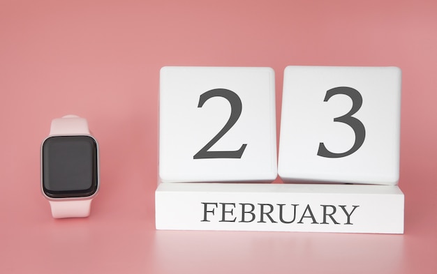 Photo modern watch with cube calendar and date 23 february on pink background. concept winter time vacation.