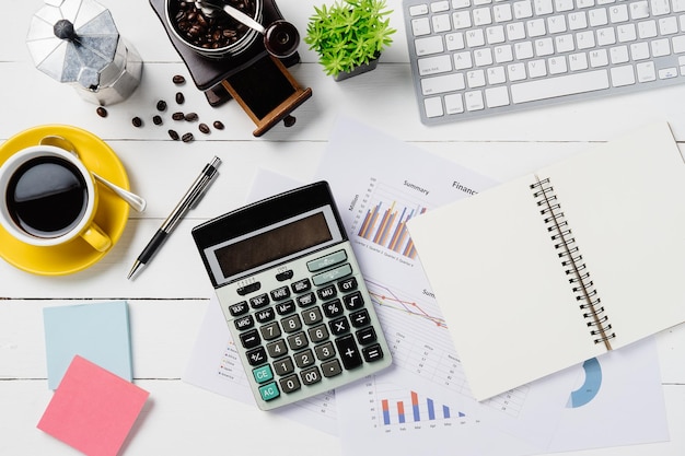 Photo modern white office desk table with keyboardpencalculatorfinancial data or graph or chart