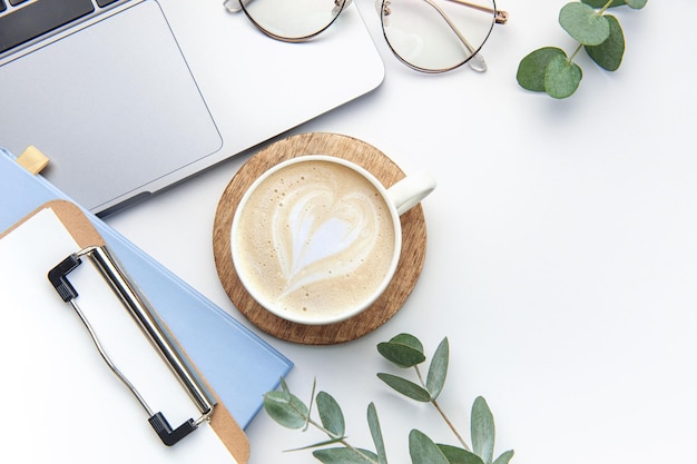 Modern white office desk table with laptop notebook and other supplies