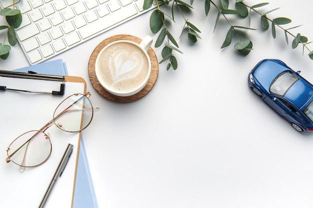 Modern white office desk table with laptop notebook toy car and other supplies