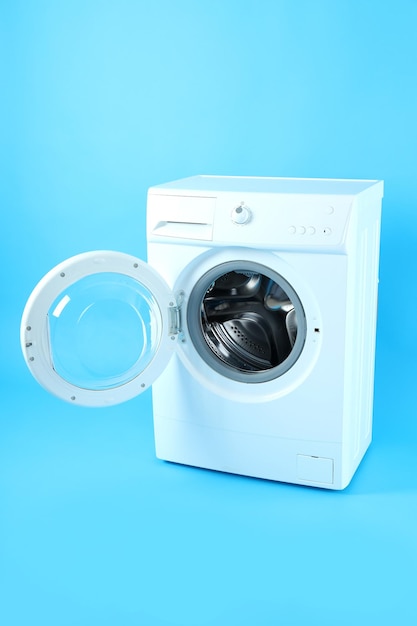 Modern white washing machine on blue background