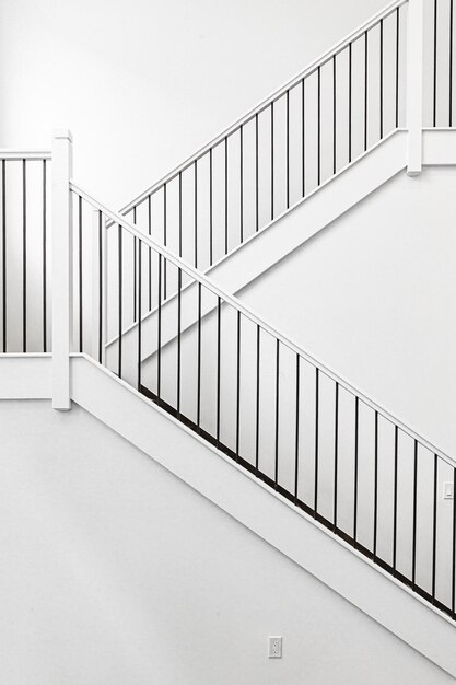 Modern white wooden staircase in new house interior with big windows