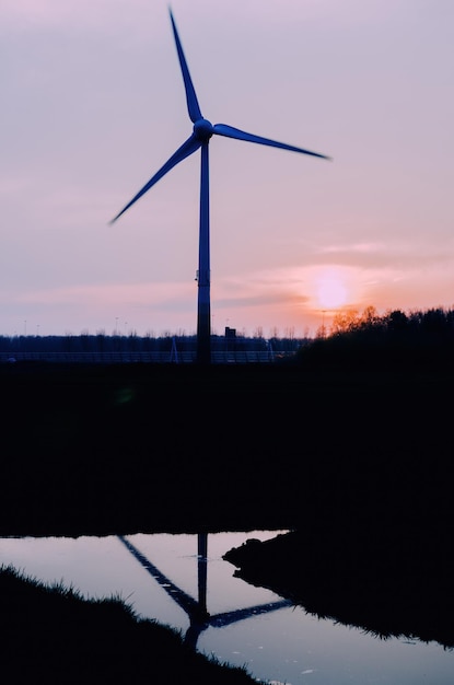 Modern windmill stand reflecting on the water in the Netherlands