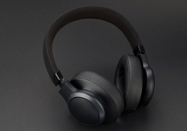 Modern wireless black headphones on a black