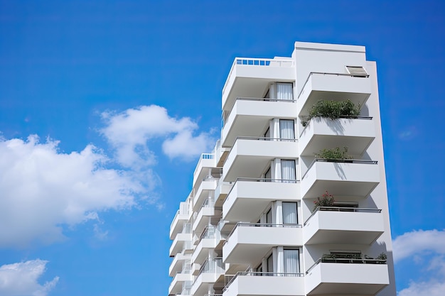 Modern wit appartementengebouw met blauwe hemel en wolken Planten en levensstijlelementen