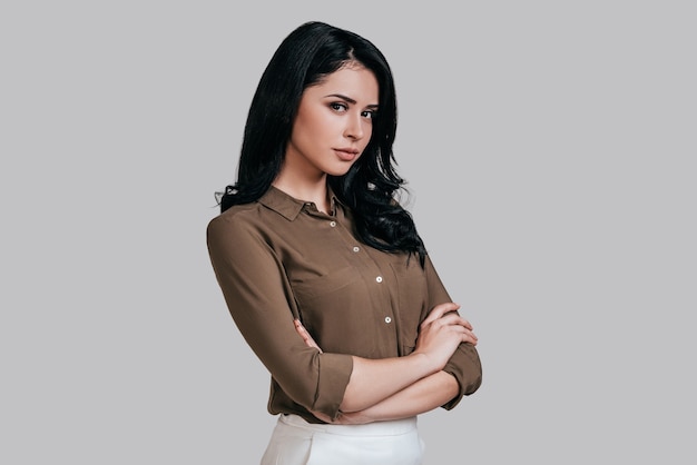 Modern woman. Beautiful young woman in smart casual wear keeping arms crossed and looking at camera 