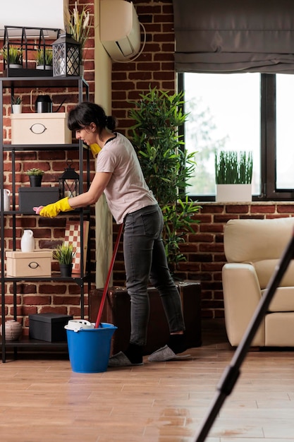 写真 春の大掃除の時間を利用して、仕事の休みの日にアパートを片付ける現代の女性。家でエネルギーを新たにすることに専念して家事をする。