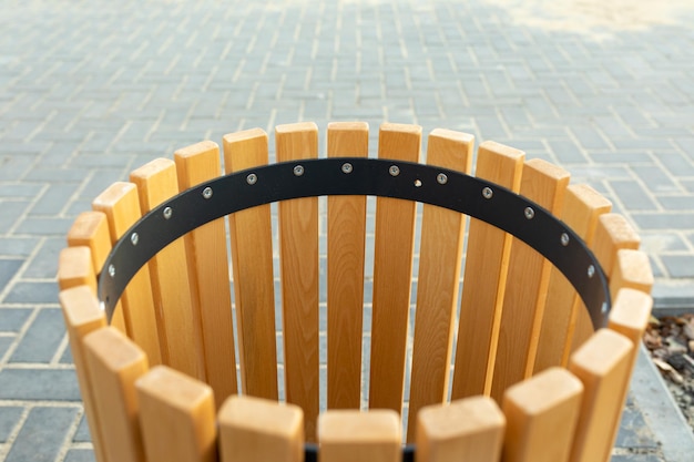 Modern wooden round trash can on paving slabs