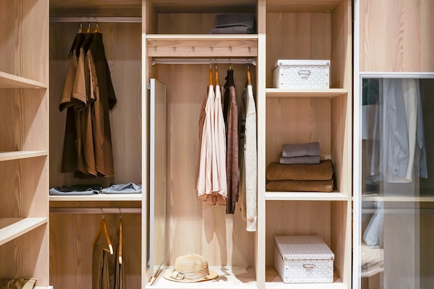 Photo modern wooden wardrobe with clothes hanging on rail