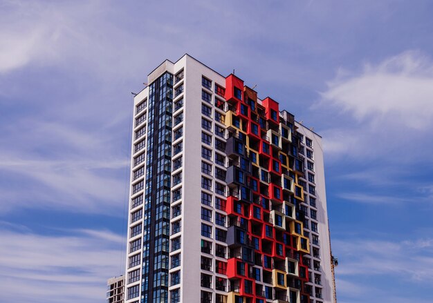 Modern woongebouw met een heldere gevel tegen de blauwe lucht. hypotheek en bouw