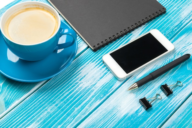 Modern workplace with cup of coffee on wooden table