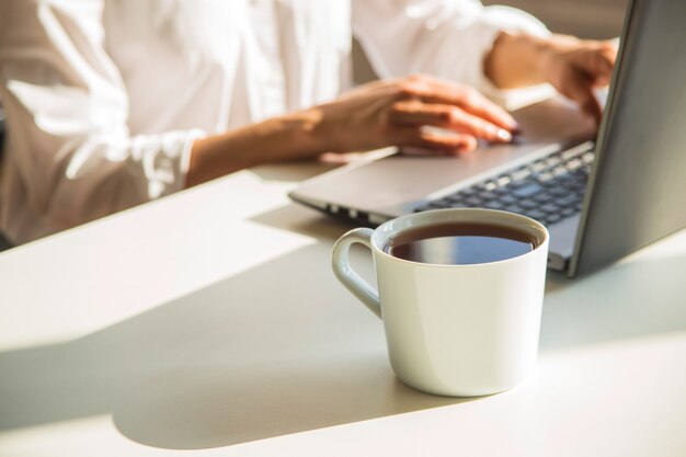 Luogo di lavoro moderno con il computer portatile nell'ombra.