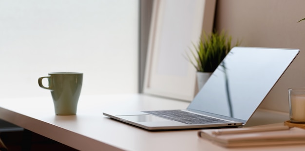 Modern workplace with open blank screen laptop 